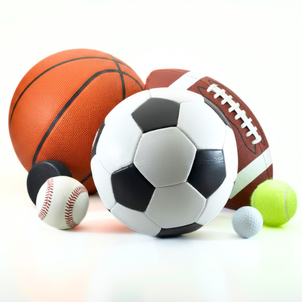 An assortment of sports equipment including a basketball, football, soccer ball, baseball, hockey puck, tennis ball, and golf ball against a white background.