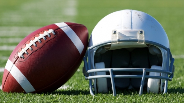 A football leaning against a helmet