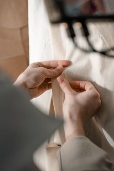 Detailed view of hands sewing with pins and fabric, perfect for DIY and crafting themes.