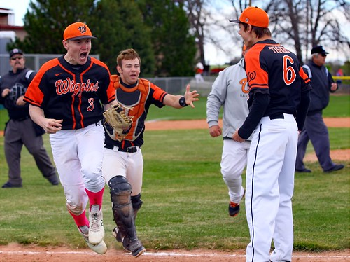 Wiggins Tigers celebrate what they believed was a seven-inning, 2-1 victory. Left to right: Bryce Ford, Devon Harshman, coach Aaron Phillips, Eric Flores -  PLDL6921