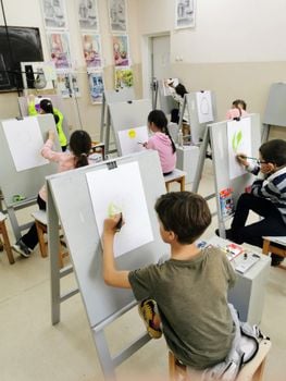 A group of children actively participating in drawing activities during an art class.
