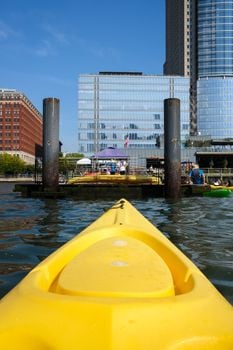 Urban kayaking experience with city skyline backdrop on a sunny day.