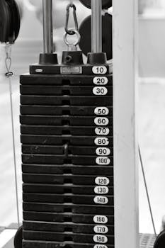 Monochrome view of a weight stack in a gym, showcasing various weight increments.