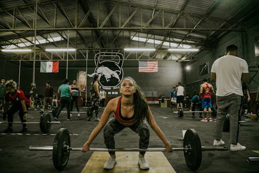 A diverse group of people engage in weightlifting at an indoor gym. Motivated focus.