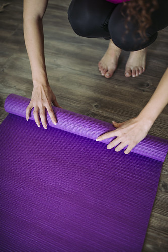 A woman rolling up her exercising mat
