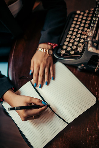 Creative writing session at a vintage typewriter with handwritten notes