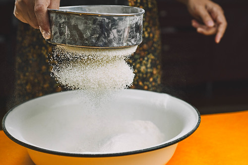 Woman hands sieving flour