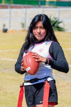 Young woman holding an American football during a training session in Toluca de Lerdo, Mexico.