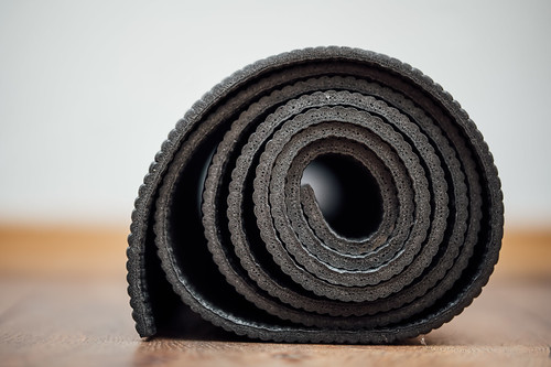 Close-up of a rolled up yoga mat on the floor