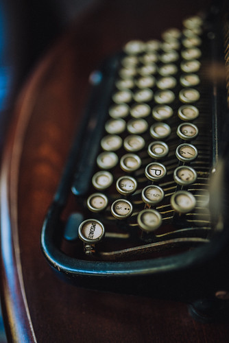 Close-up view of vintage typewriter keys resting on a wooden table