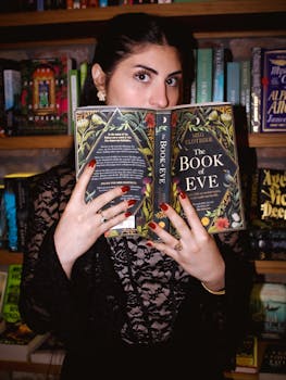 A woman reads 'The Book of Eve' by Meg Clothier in a cozy library setting, creating a mysterious mood.