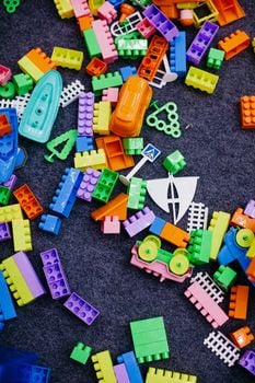 Vibrant assortment of plastic building blocks spread across a carpet, showcasing creative play.