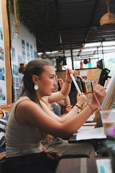 Women engaging in creative painting during an indoor art class workshop.