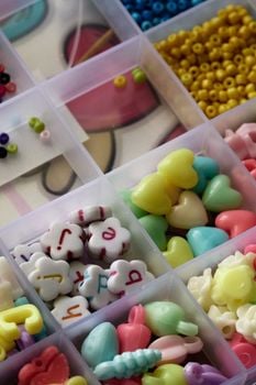 A close-up of assorted colorful plastic beads neatly arranged in a transparent organizer.