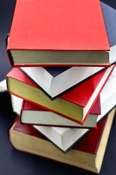 A diverse stack of hardcover books with red and black covers, perfect for education-themed projects.