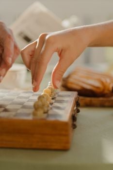 Close-up of hands playing a board game, creating a strategic atmosphere indoors.