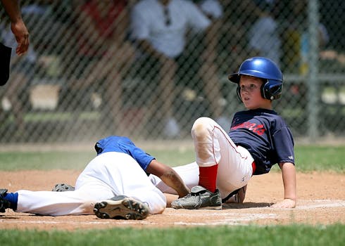 Young baseball players in action during an intense game at a sunlit field.