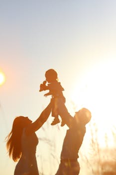 Silhouettes of Parents Holding Child in Hands 