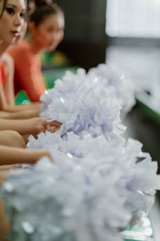 Cheerleaders with pom poms in a vertical shot, highlighting selective focus for dramatic effect.