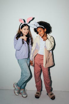 Two children wearing bunny ears sharing smiles and laughter indoors.