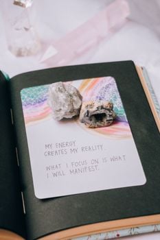 Open journal featuring crystals and an inspiring manifestation quote, perfect for motivation seekers.