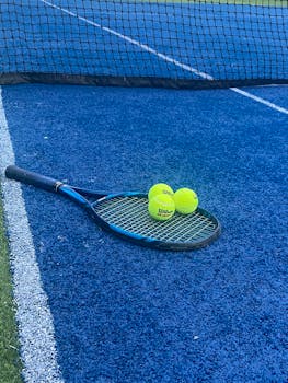Tennis equipment on a blue court in Gurugram, India. Vibrant sports imagery.