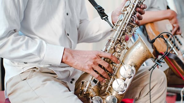Detailed shot of a musician playing a saxophone during a performance. Captures the essence of live music.