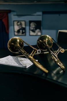 Close-up of two trombones and sheet music in a jazz setting.
