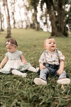 Two babies enjoying a serene outdoor setting, surrounded by nature.