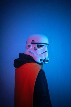 A person in a stormtrooper helmet poses with vivid lighting, highlighting sci-fi themes.