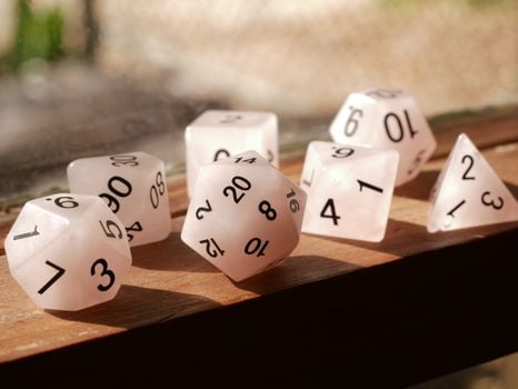 High-quality image of polyhedral dice on a wooden surface, perfect for gaming enthusiasts.