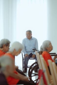 Elderly individuals in a Jakarta meeting room, promoting community and socialization.