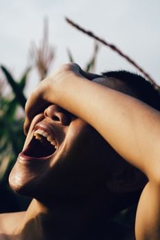 Close-up of a joyful person outdoors in natural light.