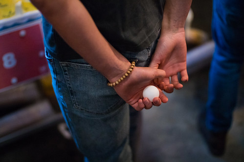 Man holding a ping pong ball in his hand behind his back